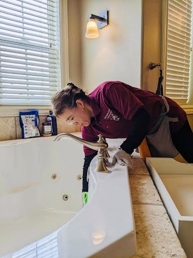 Cleaner wiping bathtub with a smile